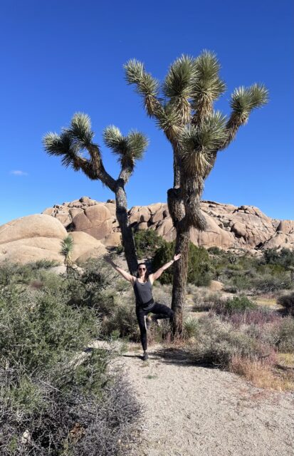 Me doing tree pose in from of a joshua tree in Joshua Tree National Park